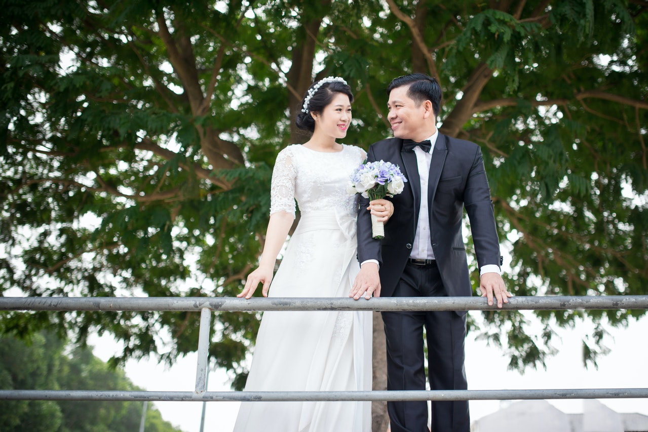 Couple Smiling While Standing Near Handrail