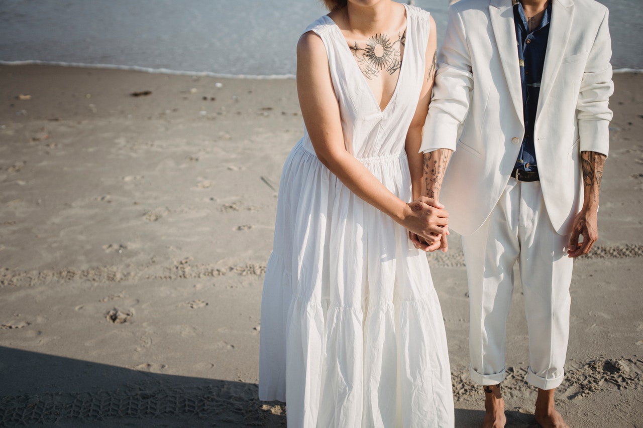 Woman in White Sleeveless Dress Standing on Beach with a Man