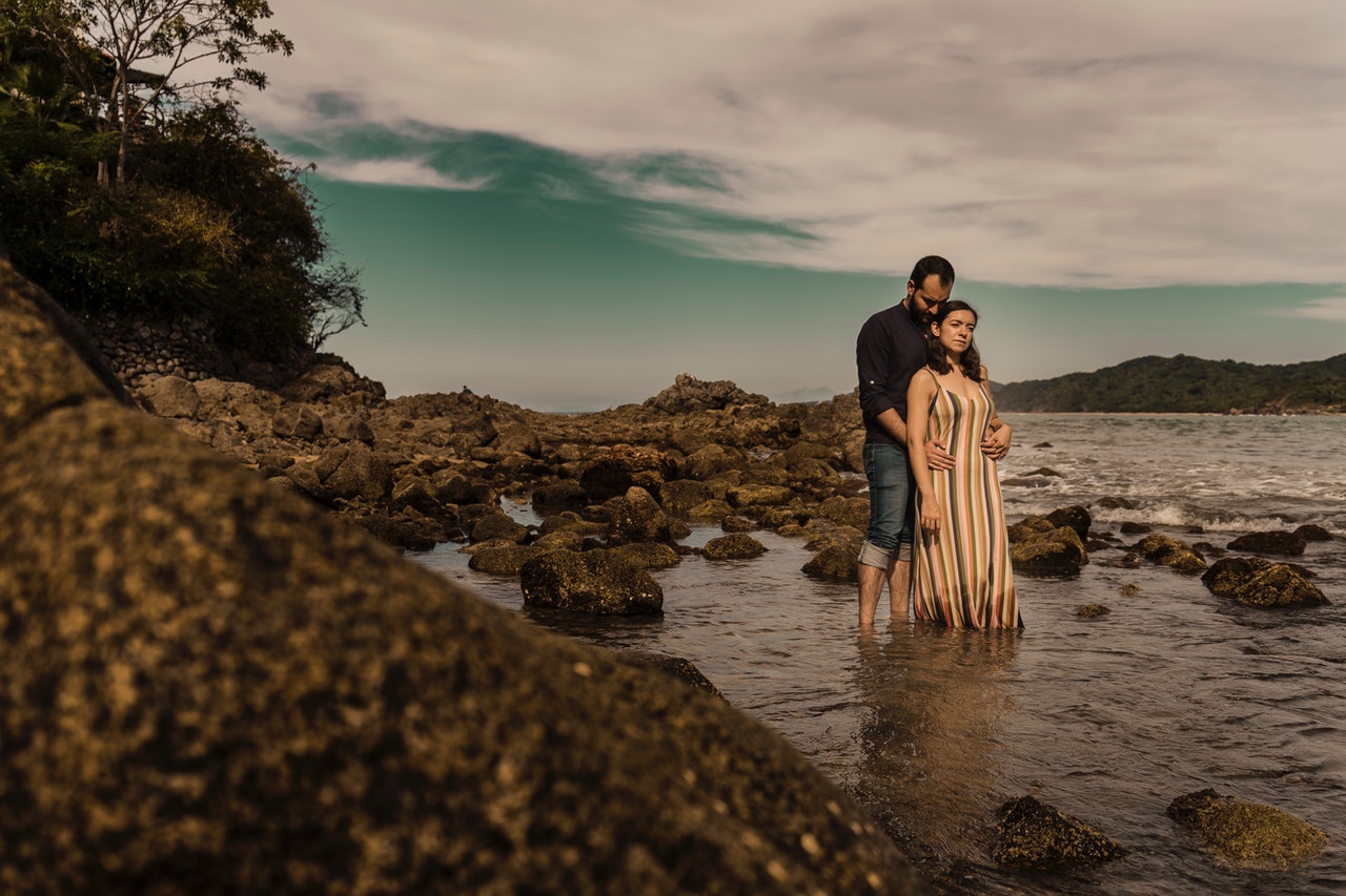 Sweet Moments of a Romantic Couple Standing on a Rocky Beach