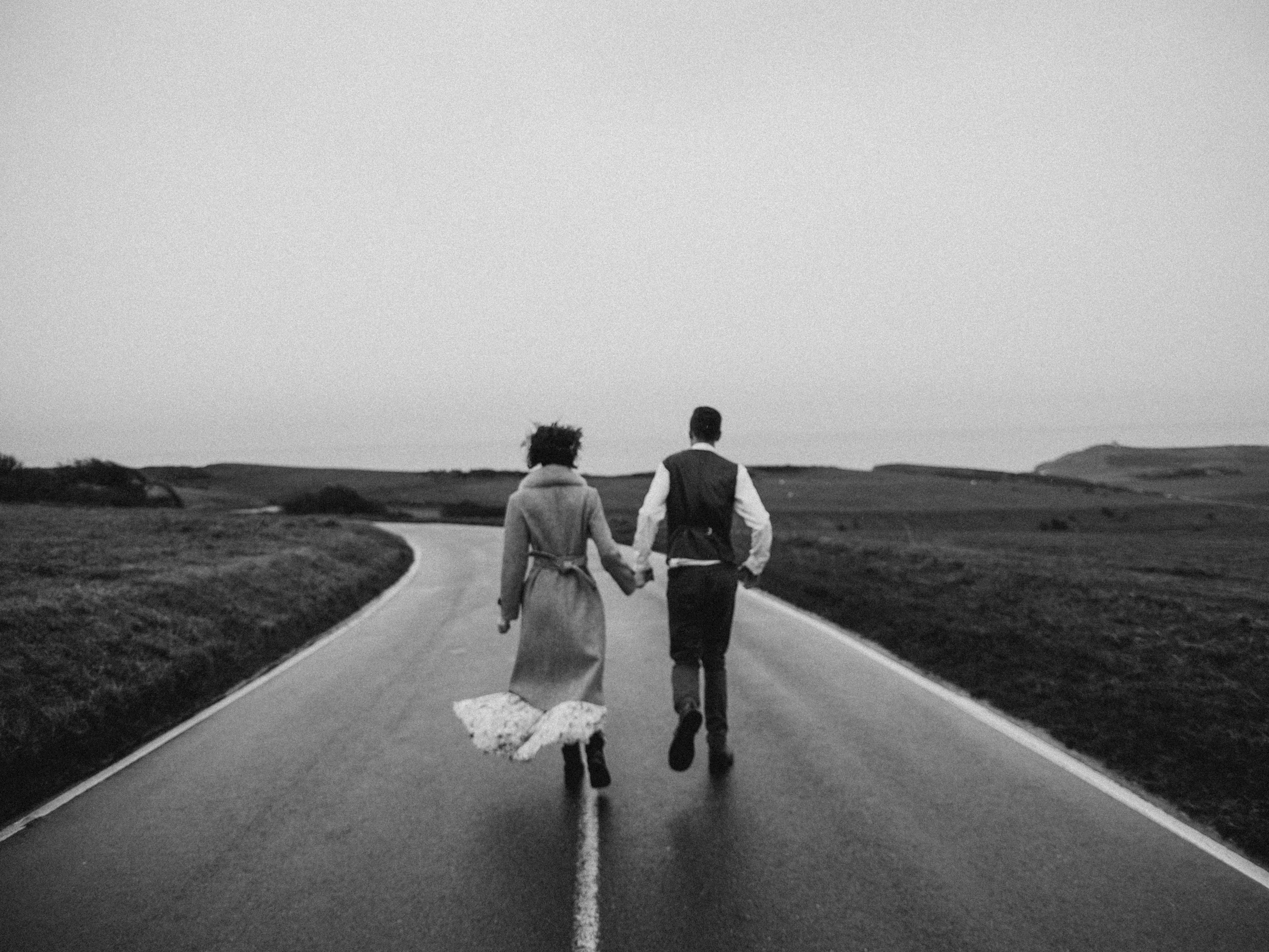 Grayscale-photo-of-couple-walking-on-road-3617517.jpg