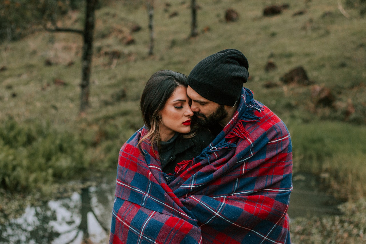 Couple Hugging With Red and Black Blanket Outdoors