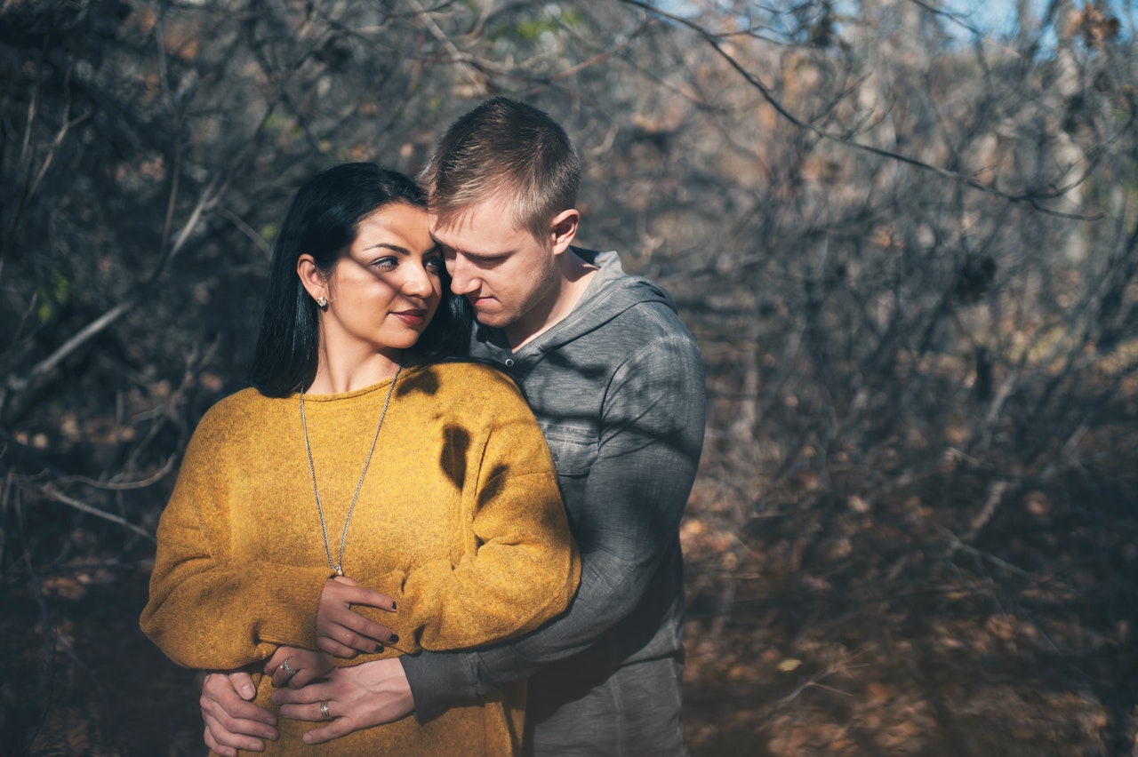 A Man Hugging A Woman from Behind In The Woods