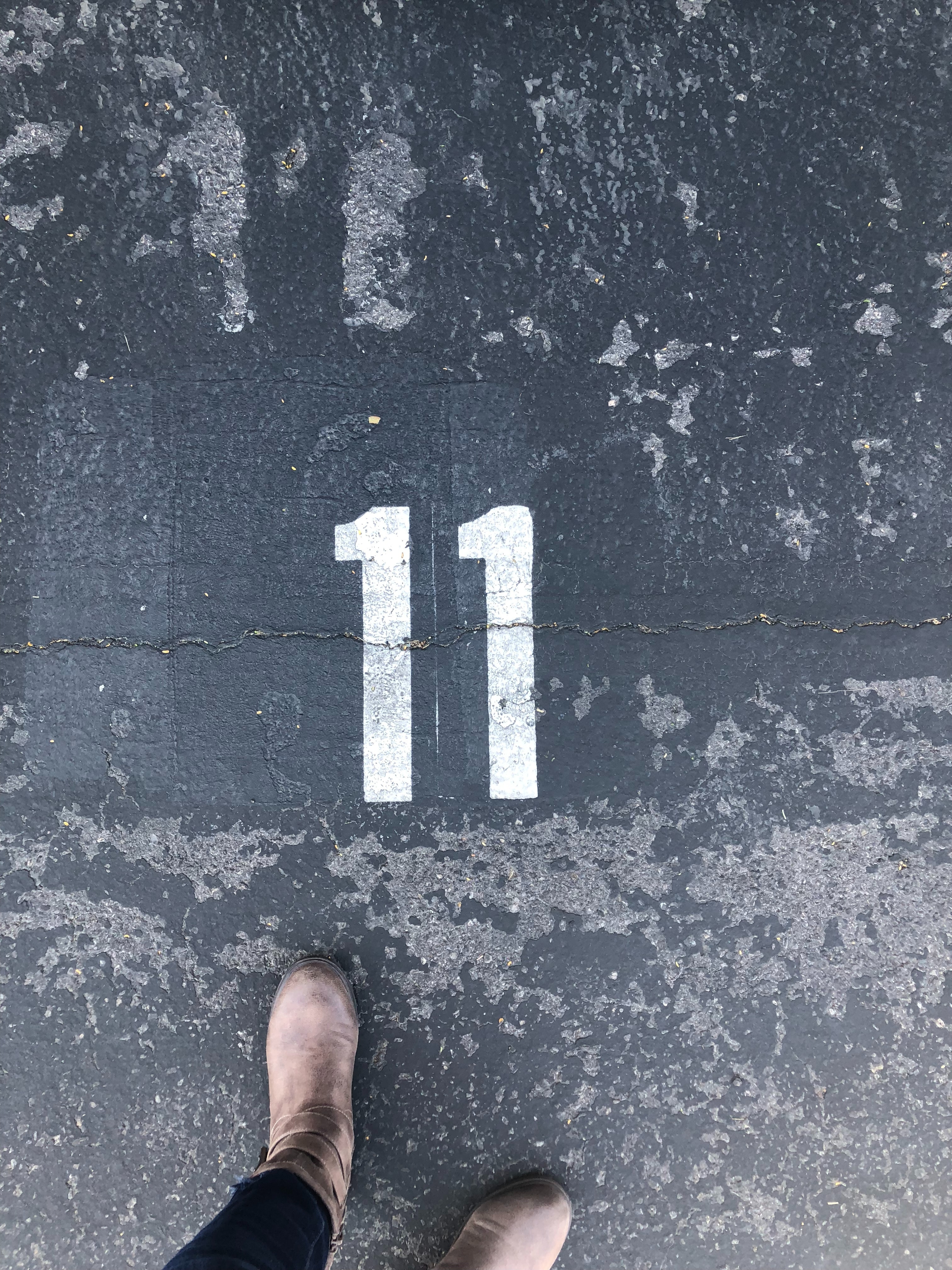 Person-standing-on-concrete-floor-with-number-11-paint-1655998.jpg