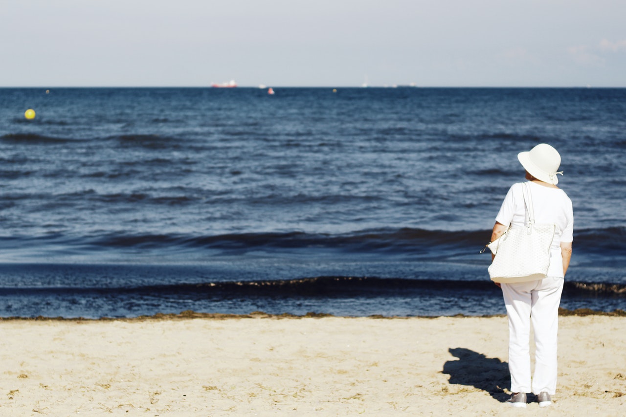 Woman In all White Standing on Seashore