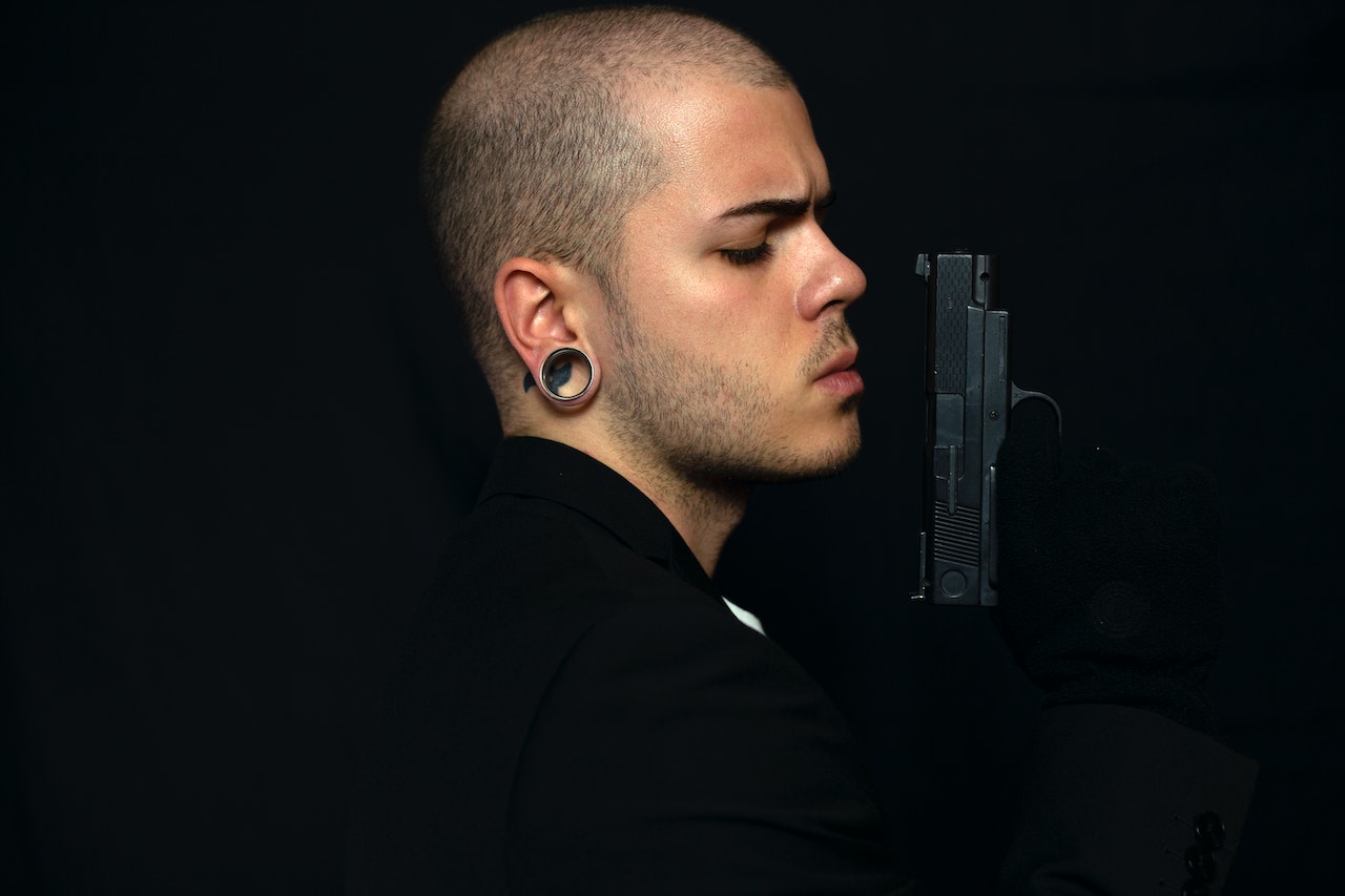 A Man in Black Shirt Holding a Black Pistol