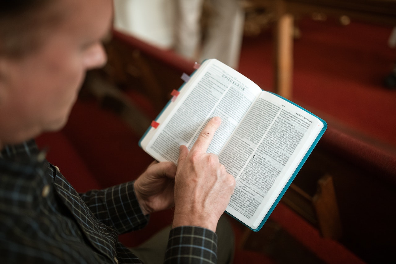 Person Holding an Open Bible