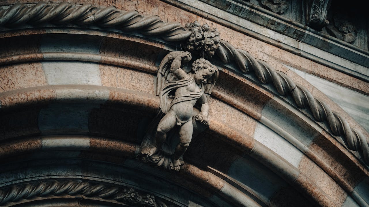 Ancient Angel Sculpture on a Building's Arch Entrance