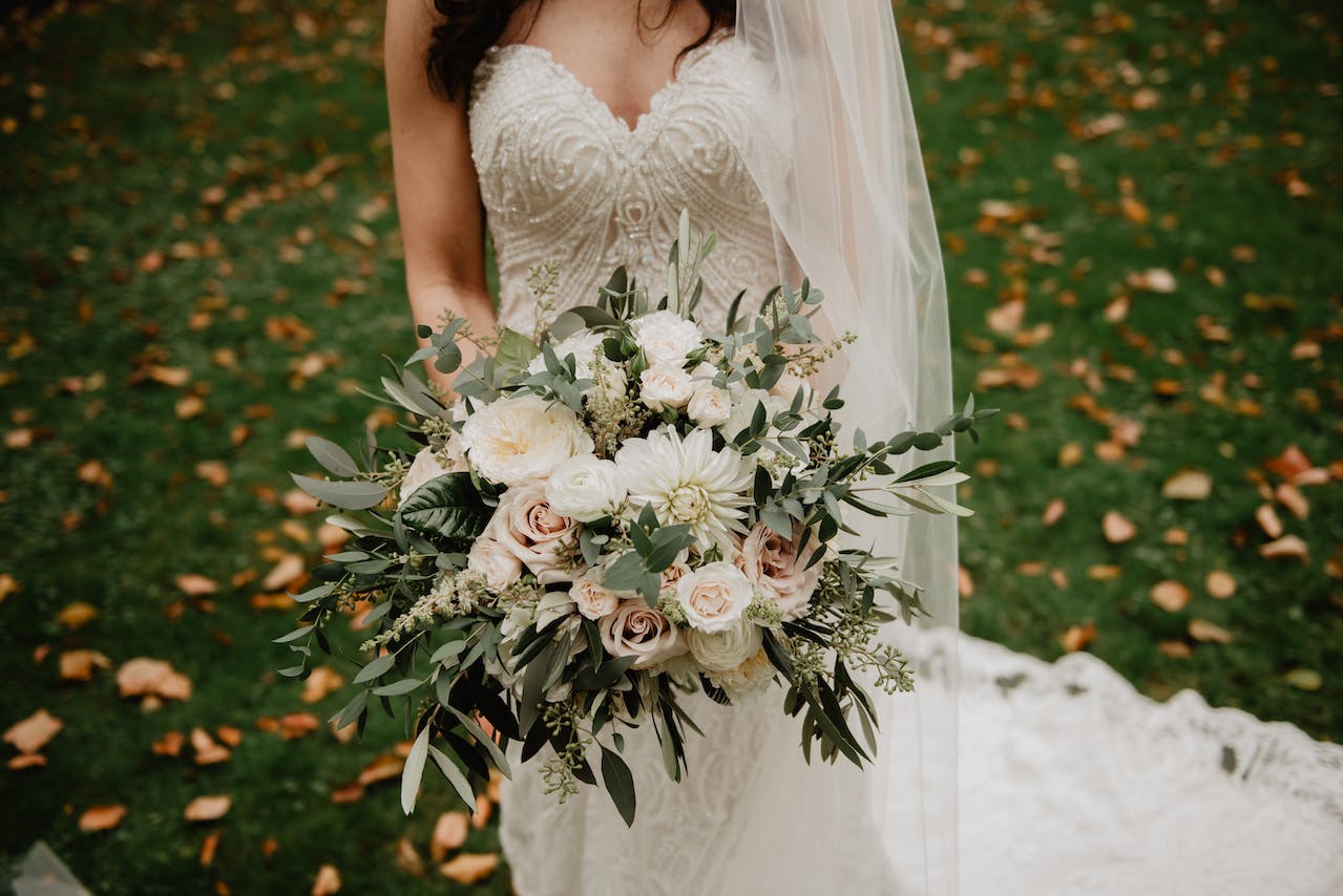 Woman Wearing White Wedding Dress With Bouquet Of Flowers