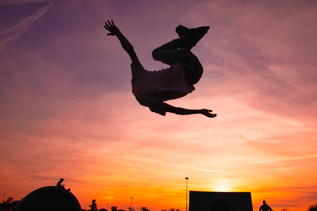 Person in White Shirt Jumping during Sunset